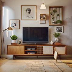 a living room with an entertainment center and pictures on the wall