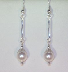 Classy! That's all you can say about these earrings. Beautiful Swarovski 6mm white Swarovski pearls capped with lacey silver bead caps and accompanied by tiny silver beads. Earrings come in a pretty gift box. Available on French wires, leverbacks or posts. I also have many sterling silver earrings (with or without cubic zirconias) that you can upgrade to (see some of my other listings or convo me - we'll talk). These can be made with any color that Swarovski pearl color that Swarovski has in the Elegant Dangle Earrings With Bead Caps, Elegant Bead Caps Drop Earrings Jewelry, Elegant Drop Earrings Jewelry With Bead Caps, Elegant Drop Earrings With Bead Caps, Elegant White Pearl Earrings, Elegant Round Earrings With Bead Caps, Elegant Silver Earrings With Bead Caps, Adjustable White Pearl Earrings With Round Beads, White Bead Caps Earrings For Gift