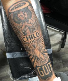 a man with a tattoo on his arm that says child of god and an angel