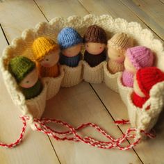 small knitted dolls in a basket on a wooden floor