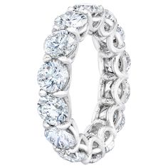 a white gold ring with six round diamonds in the center and an intricate design on the side