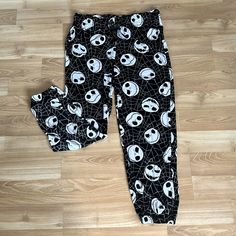 a pair of black and white pajamas with skulls on them sitting on a wooden floor