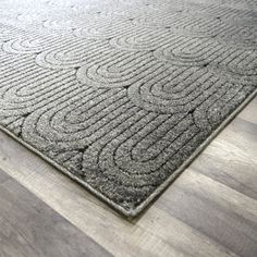 a large gray rug on top of a wooden floor