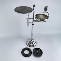 a metal table with two pots on it and an object in the shape of a chair