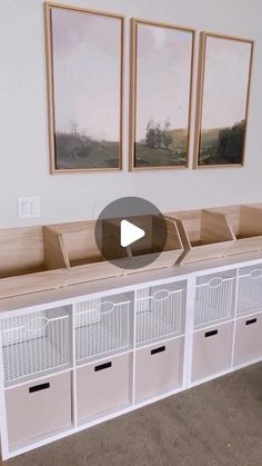 an empty room with white cabinets and pictures on the wall