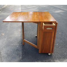 a wooden desk sitting on top of a street next to a parking lot with no one around it