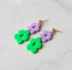 These are a bright and colorful, yet simple addition to any outfit to bring it to life with a two toned accessory. Very vintage and retro flower dangle design, the lavender and green color combo packs a punch and are perfect for fun spring moment! C A R E I N S T R U C T I O N S - Store in a clean, dry place. To clean polymer clay pieces, rub gently with a soft, wet piece of cloth. If you notice any makeup that gets on the clay from wearing it, it is safe to use pure acetone on a q-tip to clean Trendy Green Flower-shaped Earrings, Retro Flower Shaped Earrings For Gift, Retro Flower Shaped Earrings As Gift, Retro Flower Shape Earrings For Gift, Retro Multicolor Flower Jewelry, Trendy Green Flower Shaped Jewelry, Retro Multicolor Flower Earrings For Gift, Retro Flower-shaped Earrings For Gift, Clay Pieces