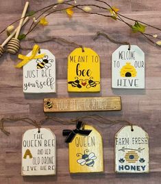 wooden tags hanging on a wall with flowers and honeycombs in the back ground