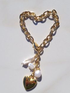 "This Sylvie Gabrielli My Only Heart Bracelet is a beautiful handmade accessory composed of freshwater pearls and a vintage heart charm. The combination of these quality materials makes this a timeless piece that is sure to be treasured for years to come. My Only Heart Bracelet features a plated gold link chain, drops of Freshwater Pearls with a Vintage Heart Charm.Features:- Authentic Vintage Gold Heart Bead- Freshwater Pearls- Lobster ClaspDimensions:-Length: 7.5\"-Extension: 2\"- Heart Diamet Heart-shaped Pearl Charm Bracelet For Wedding, Heart-shaped Pearl Bracelet With Charm For Wedding, Heart-shaped Pearl Bracelet For Wedding, Heart-shaped Pearl Charm Bracelets For Weddings, Pearl Heart Bracelet With Charm, Pearl Heart Bracelet For Wedding, Valentine's Day Pearl Bracelet With Heart Charm, Valentine's Day Heart Charm Pearl Bracelet, Wedding Pearl Heart Bracelet