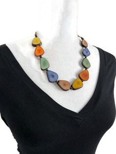 Multi Color Tagua Necklace  Necklace Length: 34 inches adjustable to shorter length Earrings Length: 1.17 inches About Tagua This Product is handcrafted from a palm tree nut native to the lush tropical rainforests of Ecuador. Also referred to as the Ecuadorean Ivory Palm, the Tagua tree produces several bushels of seed pods a year with up to 100 Tagua nuts per pod. These nuts are then harvested, dried, and crafted into a wide range of products from vibrant modern jewelry, ornate figurines, to ev Unique Necklaces For Everyday Wear, Everyday Adjustable Fair Trade Jewelry, Everyday Multicolor Necklaces With Adjustable Chain, Everyday Multicolor Necklace With Adjustable Chain, Elegant Multicolor Beaded Necklaces For Everyday, Multicolor Lariat Necklace With Adjustable Chain, Bohemian Necklaces 16 Inch Length, Multicolor Long Beaded Necklaces With Adjustable Chain, Multicolor Beaded Long Necklace With Adjustable Chain