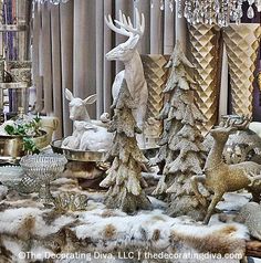 a table topped with lots of different types of christmas trees and deer figurines