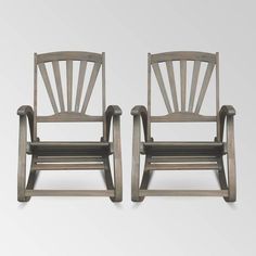 two wooden chairs sitting next to each other on a white surface with no one in it