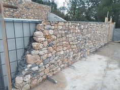 a stone wall next to a building under construction