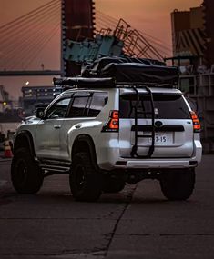 a white truck with luggage strapped to it's back