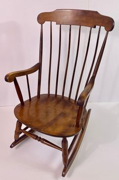 a wooden rocking chair sitting on top of a white floor