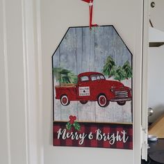 a christmas ornament hanging on the door with a red truck painted on it