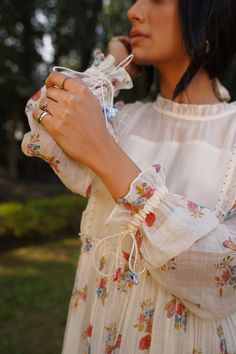 Off white handwoven cotton silk dress with frill neck, all over ladybug, dragonfly, floral pattern hand painting, pleated tiered panels, puff sleeves, kantha and pearl embroidered yoke. Paired with square neck inner slip.
Components: 2
Pattern: Hand Painted and Embroidered
Type Of Work: Floral, Ladybug, Dragonfly Pattern, Kantha and Pearl Work
Neckline: Dress: Frill Neck, Inner Slip: Square Neck
Sleeve Type: Dress: Puff Sleeves, Inner Slip: Sleeveless
Fabric: Handwoven Cotton Silk
Color: Off Whi White Cotton Dress With Gathered Neckline, White Bohemian Dress With Gathered Sleeves, Floral Print Cotton Voile Dresses, White Cotton Voile Dress, Spring Floral Print Cotton Voile Dress, Traditional Summer Dresses With Gathered Sleeves, Embroidered Floral Dress, Dragonfly Pattern, Cotton Silk Dress