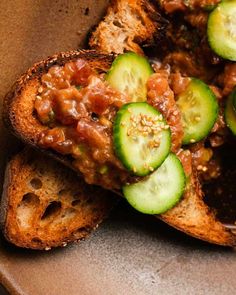 a bowl filled with bread and cucumbers on top of it