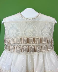 An elegant and unique gown for babies, unisex. It is made with beautiful laces and ribbons making this gown special. It comes with a bonnet and has buttons on the back for closure. Dry Clean Made in Spain Final Sale, no exchanges nor returns will be accepted Ceremonial Dress With Lace Trim And Fitted Bodice, Ceremony Dress With Lace Trim And Fitted Bodice, White Wedding Dress With Ribbon Detail, Sleeveless Lace Bodice Dress For Ceremony, Cream Ruffled Baptism Dress For Dress-up, Cream Baptism Dress With Lace Bodice, Elegant Cream Baptism Dress With Lace Patchwork, Cream Lace Baptism Dress With Lace Trim, Ceremony Baptism Dress With Lace Trim And Fitted Bodice