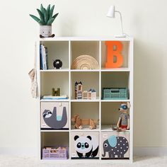 a white book shelf filled with books and toys