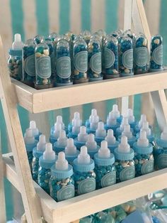 there are many baby bottles on the shelf and one is filled with blue liquid,