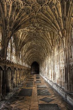 the inside of an old building with stone floors and arches on either side of it