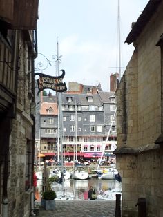 an alley way with boats docked in the water and buildings on either side that are bricked