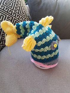 a crocheted fish hat sitting on top of a couch