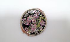 a compact case with flowers on it sitting on a table