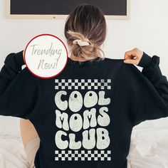 Design: Retro Cool Moms Club Sweatshirt Size: Garments are unisex. Refer to size chart for details. Care: Turn garment inside out and wash on cold, gentle cycle. Tumble dry low. Do not iron on print.  Make: Gildan 18000 Heavy Blend Crewneck Sweatshirt, a unisex heavy blend crewneck sweatshirt. These garments are made from a blend of polyester and cotton. The collar is ribbed knit, so it retains its shape even after washing. There are no itchy side seams on these sweatshirts.  Returns:  All products are made to order, therefore returns, refunds, and exchanges are not accepted unless item arrives misprinted/damaged/defective. Family Matching Graphic Print Sweatshirt, Cozy Black Tops With Graphic Print, Cozy Black Top With Graphic Print, Family Matching Crew Neck Sweatshirt With Graphic Print, Cozy Black Top With Letter Print, Cool Moms Club, Club Sweatshirts, Moms Club, New Mom Gift