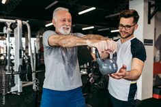 two men working out with kettles in the gym