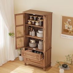 a wooden cabinet with drawers and shelves filled with dishes on top of it next to a window