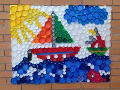 a painting made out of plastic bottle caps on a brick wall with a sailboat in the background