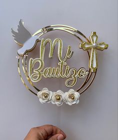 a person holding up a cake topper that says me, beautigo with flowers and a dove on it