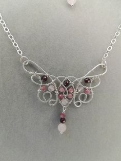 A beautiful rose quartz pink tourmaline and purple garnet neclace in elven style for you! Made to last with .925 Sterling silver wire and rose quartz, pink tourmaline and Madagascar purple garnet beads. The pendant is 2.5 inches wide and 2.5 inches long including the dangle on the bottom.  It's on an 18 inch chain, so the total length is just over 21 inches. The dangle earrings are 2.5 inches long and 5/8 inches wide. Pink Amethyst Wire Wrapped Jewelry, Silver Wire Wrapped Rose Quartz Jewelry, Silver Rose Quartz Wire Wrapped Jewelry, Elven Style, Purple Garnet, Quartz Pink, Beautiful Rose, Silver Roses, Pink Tourmaline