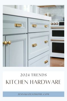 a kitchen with white cabinets and gold handles