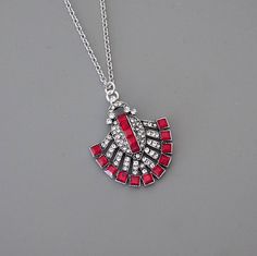 "Vintage Jewelry - Art Deco Inspired Necklace - Ruby Red Necklace - Crystal Necklace - Silver Necklace - Chloe's Vintage JewelryHandmade This is such a gorgeous Art Deco inspired necklace!  A stunning design embellished with sparkling red and clear crystals.  The pendant hangs from a silver plated chain.   Chloe says, \"Wear it and feel fabulous!\" The pendant measures 1 1/2\" long.  You can choose the length you would like at checkout. Thanks for visiting Chloe's" Red Jewelry With Lobster Clasp For Party, Red Party Jewelry With Lobster Clasp, Red Pendant Necklace With Lobster Clasp, Red Pendant Necklace Costume Jewelry, Red Pendant Costume Jewelry Necklace, Red Pendant Necklace In Costume Jewelry Style, Red Pendant Necklaces For Party, Vintage Red Necklace With Lobster Clasp, Vintage Red Jewelry With Adjustable Chain