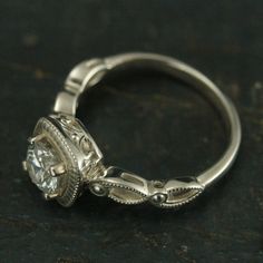 an antique style engagement ring with a center diamond