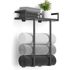 a towel rack with three rolls of towels and a potted plant on top of it