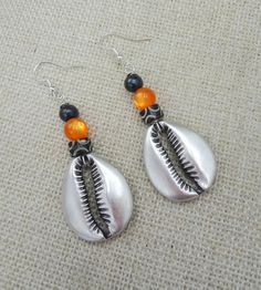 The silver plated cowrie is beaded with carved and glass beads. The earrings will come with back stoppers. If you have any questions please feel free to contact us at anytime. All shipping options are available. All items will be shipped out Monday through Friday. Receipts will be emailed out for immediate access. All items will be shipped out carefully and every shipment can be made with extra insurance upon request. All other concerns and details can be found in our policy section. Our goal is for your 100% satisfaction. If you would like to make a large order please contact us for a coupon code. Our products are not intended for babies or children as we use small pieces, wires and beads. These can be dangerous to them when unsupervised. Gift boxes and gift messages are available for you Silver Teardrop Earrings For Beach, Adjustable Silver Shell-shaped Earrings, Silver Beaded Earrings With Polished Beads As Gift, Silver Polished Beaded Earrings As Gift, Silver Polished Beaded Earrings For Gift, Beach Beaded Metal Earrings, Metal Beaded Earrings For Beach, Bohemian Drop Earrings With Polished Beads, Bohemian Silver Shell-shaped Jewelry