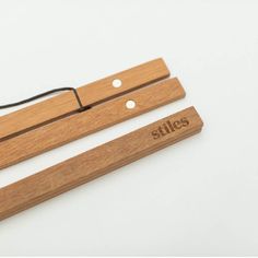 two wooden clothes pegs with the word stils written on one side and an electric cord attached to them