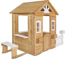 a wooden play house with white trim on the windows and doors, along with a picnic table