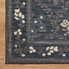 a blue rug with white flowers on the top and bottom, sitting on a wooden floor