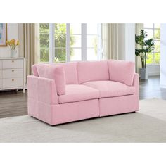 a pink couch sitting on top of a white rug