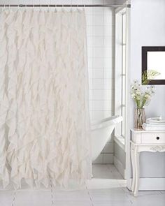 a white bath tub sitting next to a shower curtain