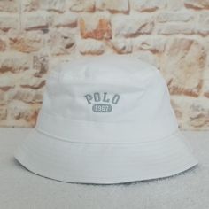 New...Not Used...Authentic Small/Medium - 22.75" Inner Circumference Fleece Bucket Hat Reverses To Solid-Hued Twill 60% Cotton, 40% Polyester., Reverse Side 100% Cotton Logo On Each Side Seamed Brim Embroidered Ventilating Eyelets Band Around The Crown "Polo" Embroidered At The Front Of One Side "Polo 1967" Embroidered At The Front Of The Reverse White Bucket Hat One Size, White Bucket Hat, One Size Fits Most, Everyday Wear, White Everyday Bucket Hat One Size, Adjustable White Bucket Hat For Everyday, White Bucket Hat With Short Brim For Outdoor, White Outdoor Bucket Hat With Short Brim, Trendy White Brimmed Bucket Hat, White Flat Brim Bucket Hat For Outdoor, Trendy White Bucket Hat For Outdoor