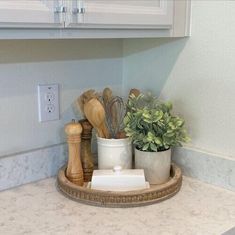 a kitchen counter with pots and utensils on it in front of a light switch