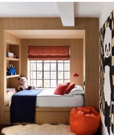 a bed room with a neatly made bed and a teddy bear sitting on the floor