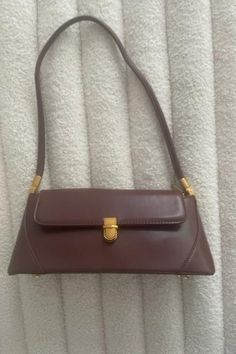 Get ready for fall with the must-have Audrey Bag! Its retro and classic design exudes chic style and will elevate any outfit. PU leather Imported Color: Burgundy Gold buckle and accents Approximate measurements: 11x4.7 in (Handle:10.62") Brown Baguette Shoulder Bag With Hasp Closure, Brown Baguette Bag With Hasp Closure For Daily Use, Brown Baguette Bag With Hasp Closure For Office, Brown Baguette Bag With Hasp Closure For Travel, Classic Baguette Bag With Hasp Closure, Classic Office Baguette Shoulder Bag, Brown Satchel Baguette Bag For Office, Chic Brown Baguette Bag With Hasp Closure, Modern Brown Baguette Shoulder Bag