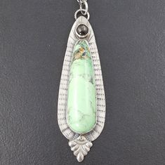 "A variscite stone is combined with a silver moonstone and set sterling silver to create this piece. The entire piece has been oxidized to bring out the detail. The pendant hangs from a sterling silver 24\" that is adjustable due to the nature of the chain. The pendant measures approx 2.75\" long. This piece is one of a kind and ready to ship. PAYMENT PLANS ARE AVAILABLE ON ALL ITEMS UPON REQUEST! CONTACT ME FOR MORE INFO To see more necklaces: http://www.etsy.com/shop/MicheleGradyDesigns?sectio Blue Stone Bracelet, Kyanite Earrings, Metalsmithing Jewelry, Precious Metal Clay, Silver Jewelry Design, Silver Work, Green Stone, Handmade Pendants, Necklace Silver